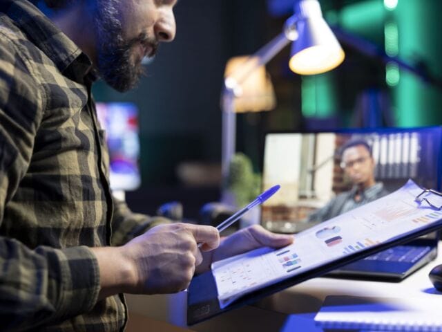 Man reviews documents while on video call