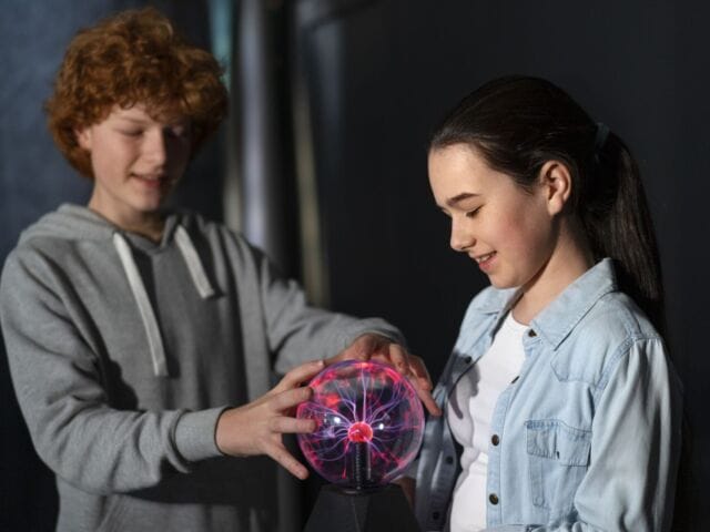 medium-shot-kids-interacting-with-plasma-ball